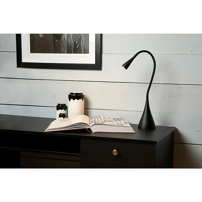 Lucide Zozy LED-Tischleuchte - 4 W, L x B x H: 11,2 x 11,2 x 48,5 cm, Schwarz, Neutralweiß - Diese Aufnahme zeigt eine elegante schwarze Schreibtischleuchte, die neben dekorativen Vasen auf einem modernen schwarzen Schreibtisch steht.