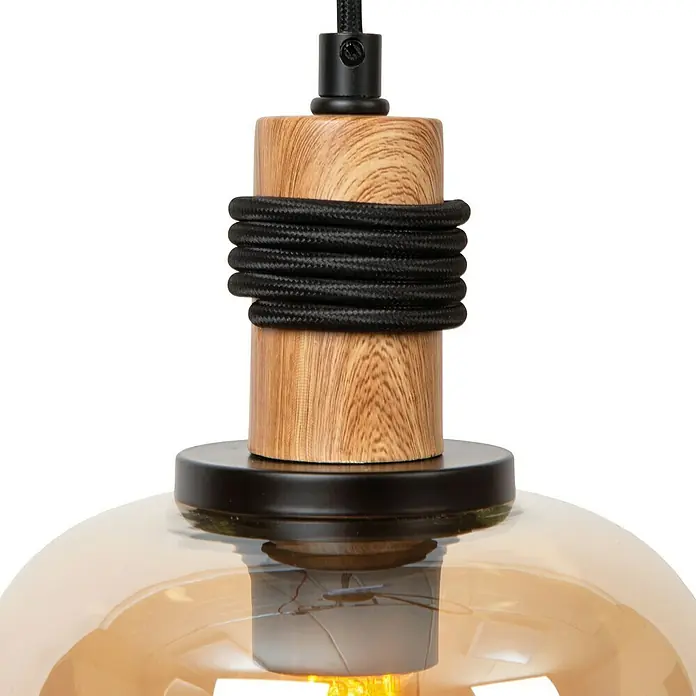 Lucide Ilona Pendelleuchte - 40 W, L x B x H: 12 x 12 x 161 cm, Amber, E27 - Nahaufnahme einer Hängelampe mit einem hölzernen Element und einem schwarzen Kabel. Das Licht der Lampe schimmert warm durch das Glas.