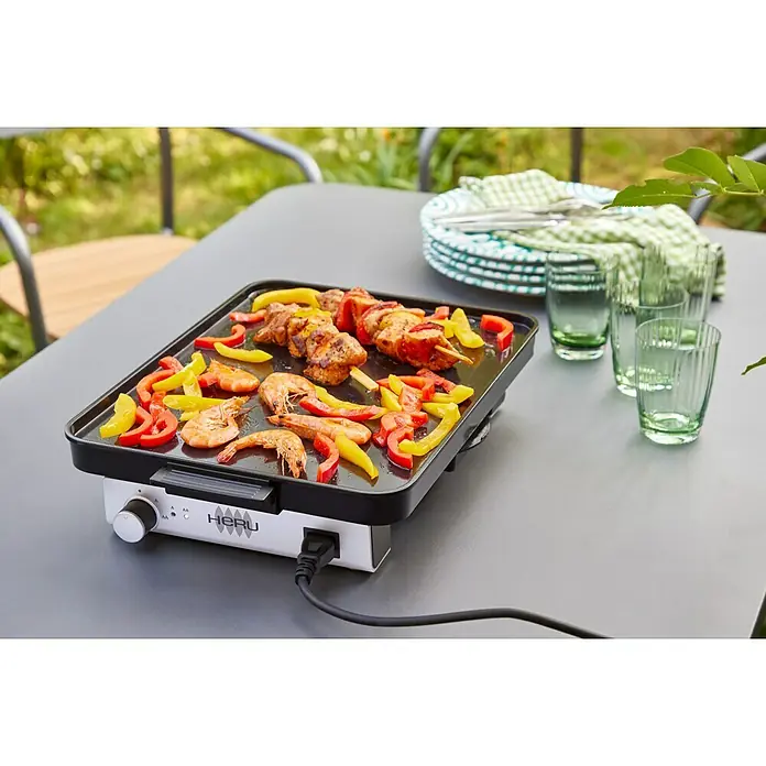 Plancha-Grill Elektro - Grillfläche (B x T): 40 x 30 cm, 1,8 kW, Schwarz/Grau - Ein elektrischer Grill mit Garnelen, Paprika und Fleischspießen auf einem grauen Tisch mit Gläsern und Tellern.