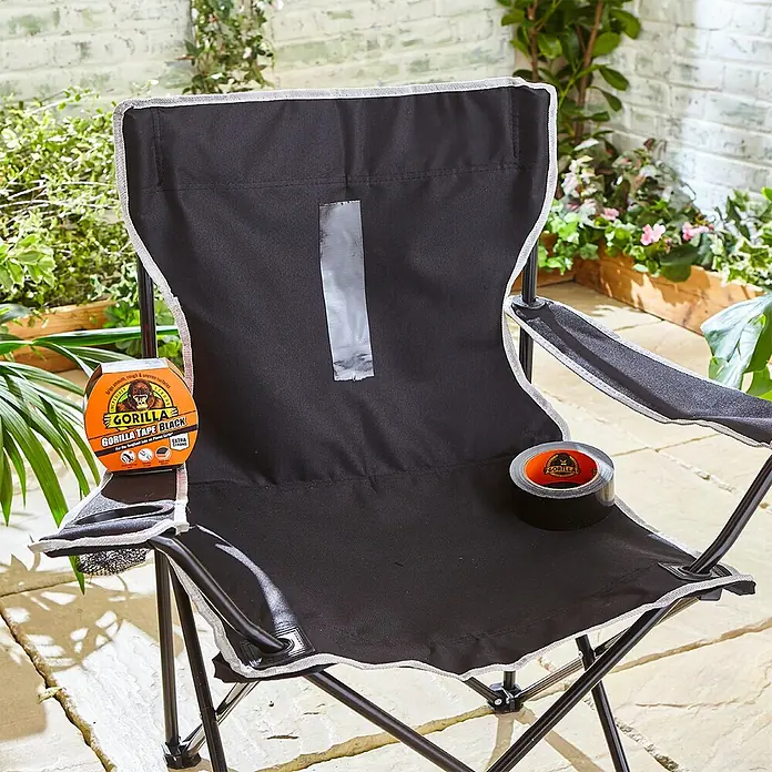 Gorilla Cinta de reparación Americana - Negro, 11 m x 48 mm - Una silla plegable negra con cinta Gorilla, tanto en rollo como en tira preaplicada, para reparaciones y comodidad al aire libre.