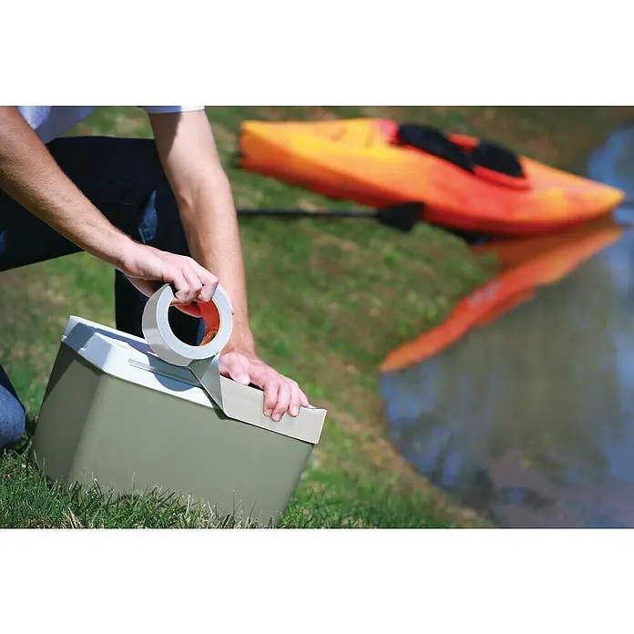Gorilla Cinta de reparación Americana - Blanco, 27 m x 48 mm - Hombre asegurando una nevera con cinta adhesiva resistente para una aventura al aire libre, con un kayak al fondo.