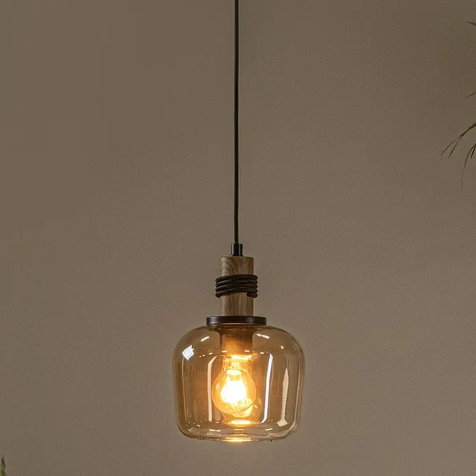 Lucide Ilona Pendelleuchte - 40 W, L x B x H: 12 x 12 x 161 cm, Amber, E27 - Eine Hängelampe mit einem bernsteinfarbenen Glasschirm und einem Holzboden. Sie strahlt ein warmes, einladendes Licht aus.