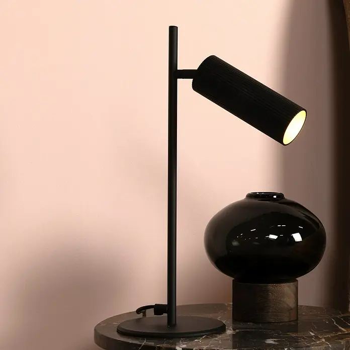 Lucide Clubs Tischleuchte - 40 W, L x B x H: 19,5 x 9 x 47 cm, Schwarz, GU10 - Nahaufnahme einer modernen schwarzen Tischleuchte mit einem zylindrischen Lampenkopf und einem passenden schwarzen Glasobjekt auf einem Marmortisch.