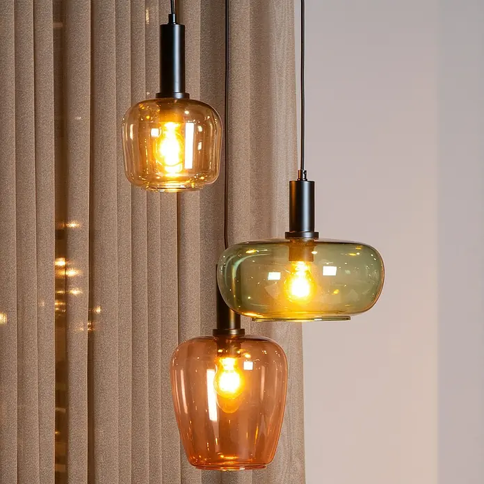 Lucide Ilona Pendelleuchte - L x B x H: 30 x 30 x 174 cm, Amber, E27 - Nahaufnahme von drei eleganten Pendelleuchten mit farbigen Glasschirmen, die warmes Licht ausstrahlen.