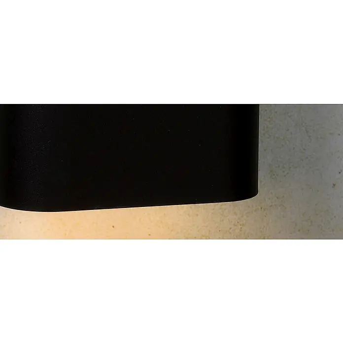 Lucide Wandleuchte Ovalis - 9 W, L x B x H: 18 x 10 x 22 cm, Schwarz/ Weiß, E14 - Nahaufnahme einer schwarzen Wandleuchte, die ein warmes, einladendes Licht auf eine strukturierte Wand wirft.