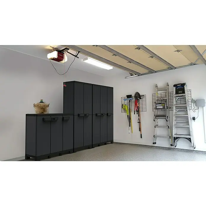 Terry Armario multiusos de plástico  Ardesia - Gris oscuro/Negro, 2 piezas - Una vista de garaje con gabinetes de almacenamiento grises, escaleras y herramientas en la pared. El foco está en los gabinetes.
