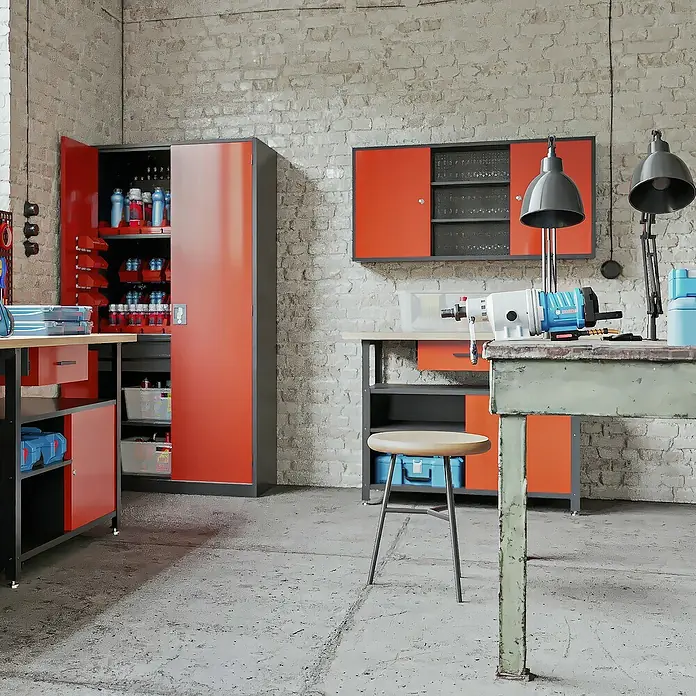 Jan Nowak Hängeschrank Ben - H x B x T: 60 x 120 x 20 cm, Anthrazit/Rot - Ein Werkstattinterieur mit Werkstattschränken in Orange und Grau. Eine Werkbank und ein Hocker ergänzen die Werkstatteinrichtung.