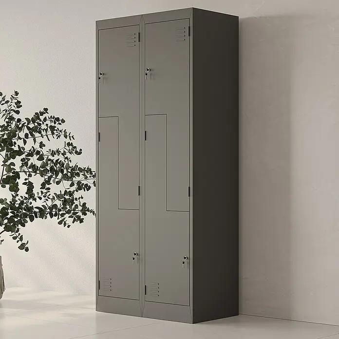 Jan Nowak Z-Spind Julia - B x T x H: 80 x 45 x 185 cm, Anzahl Türen: 4 Stk., Anthrazit - Ein grauer Metallschrank mit zwei Fächern steht an einer weißen Wand, daneben eine Pflanze. Ideal für Büro, Schule oder Fitnessstudio.