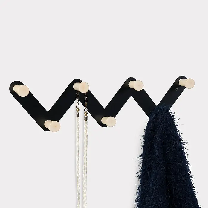 Nesu Perchero 9604 - Madera, Negro - Un perchero de pared moderno negro en zigzag con pomos color crema, con un collar y una bufanda.