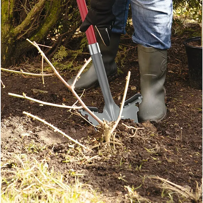 Easymaxx Multifunktionsspaten + Wurzelsäge - 114 cm, Stahl - Nahaufnahme eines grauen Unkrautstechers mit rotem Griff, der im Garten verwendet wird. Er hilft, Unkraut einfach zu entfernen.