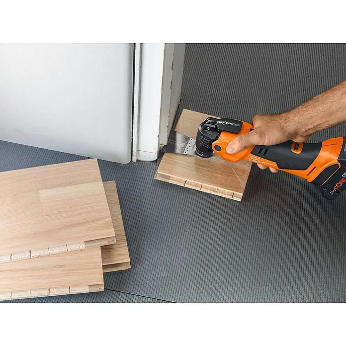 Fein AMPShare 18V Akku-Multifunktionswerkzeug MultiMaster AMM500 Plus Top AS - 18 V, Ohne Akku, Leerlaufschwingzahl: 11.000 /min - 18.500 /min - Eine Nahaufnahme eines Fein Multimasters, der zum Schneiden von Holz verwendet wird, mit Holzböden im Hintergrund.