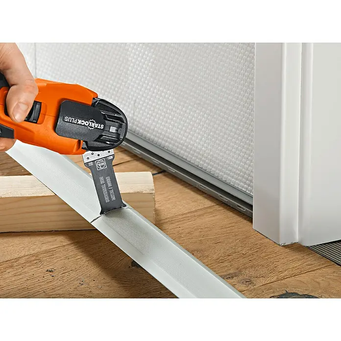 Fein Zubehör-Set Best of E-Cut Starlock Wood & Metal - 6 -tlg. - Oszillierendes Elektrowerkzeug beim Schneiden einer weißen Fußleiste auf einem Holzboden, ideal für Renovierungsarbeiten.