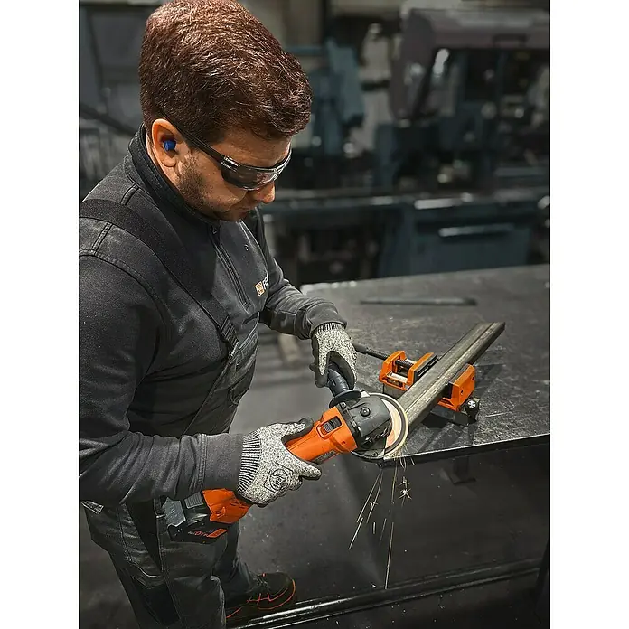 Fein AMPShare 18V Akku-Winkelschleifer CCG 18-125-12 AS - Ohne Akku, Durchmesser Scheibe: 125 mm - Ein Handwerker schleift ein Metallstück mit einem FEIN Akku-Winkelschleifer, Funken sprühen. Schutzbrille und Handschuhe sind getragen für Sicherheit.