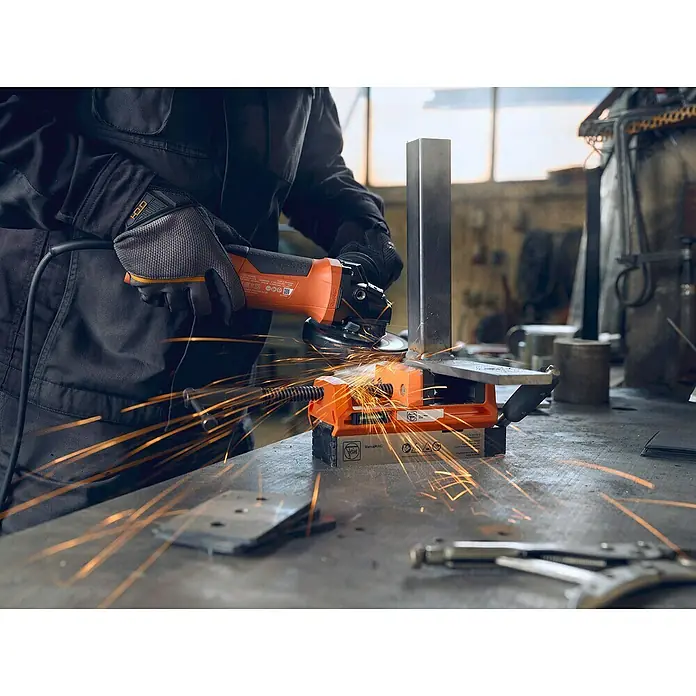 Fein Schraubstock VersaMAG - Spannweite: 108 mm, Metall - Arbeiter mit Winkelschleifer beim Schneiden von Metall mit einem magnetischen Werkstückhalter, Funken fliegen.