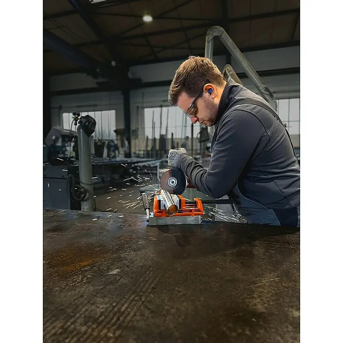 Fein AMPShare 18V Akku-Winkelschleifer CCG 18-125-12 AS - Ohne Akku, Durchmesser Scheibe: 125 mm - Ein Arbeiter mit Schutzbrille und Handschuhen schneidet ein Metallrohr mit einer Trennscheibe. Die Funken sprühen beim Schneiden des Rohrs.