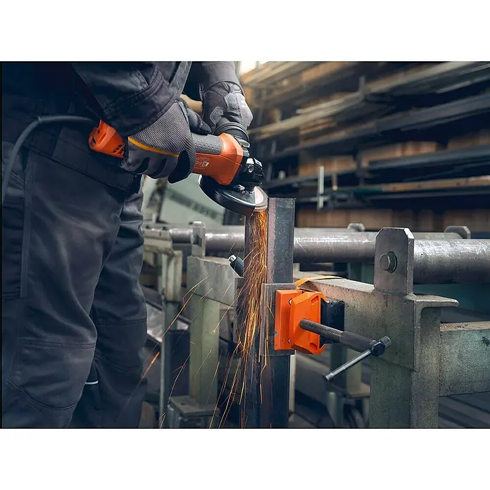 Fein Schraubstock VersaMAG - Spannweite: 108 mm, Metall - Ein Arbeiter benutzt einen Winkelschleifer mit Funkenflug, um Metall zu schneiden. Schutzhandschuhe werden getragen.