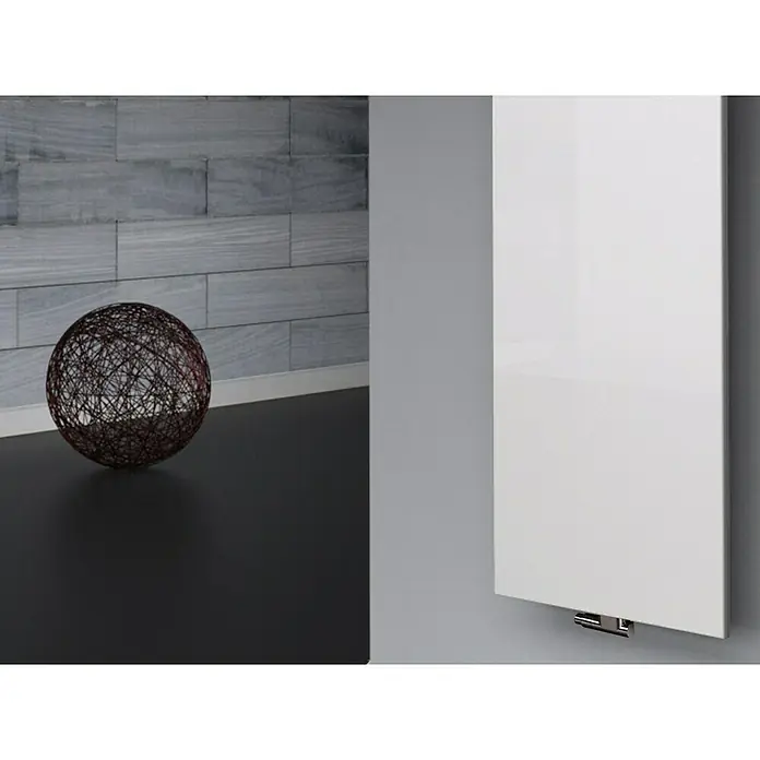 Szagato Designheizkörper Manhattan 3 - B x H: 470 x 1.800 mm, Wärmeleistung bei Vorlauftemperatur von 75 °C (D: 50): 1.118 W, Weiß, Mit 1 Handtuchhalter (50 mm) - Nahaufnahme eines weißen Heizkörpers an einer Wand mit einem dekorativen Ball davor. Schlichtes, modernes Design für behagliche Wärme.