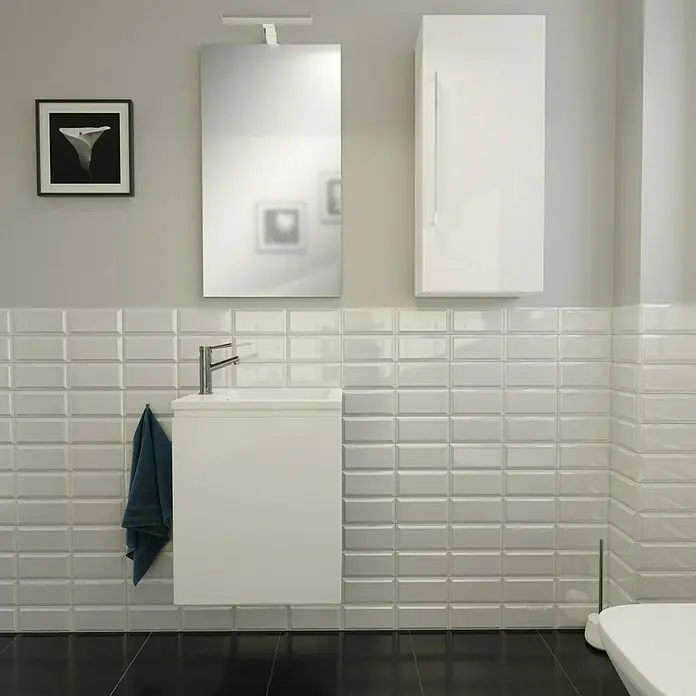 Camargue Espacio Hängeschrank40 x 17 x 90 cm, Gama weiß glänzend - Helles Badezimmer mit weißen Metrofliesen, einem schwebenden Waschtisch mit Handtuch und einem Spiegelschrank für ein modernes Ambiente.