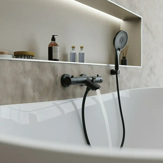Camargue Badewannenarmatur Zapo - Ausladung Armatur: 165 mm, Schwarz, Matt - Ein elegantes Badezimmer mit einer modernen, mattschwarzen Armatur, die Wasser in eine Badewanne einlässt, und einer praktischen Ablagefläche.