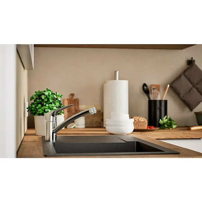 Hansgrohe Grifo de cocina Logis 120 - Cromo, Brillante - Primer plano de un fregadero moderno con grifo en una cocina elegante, rodeado de utensilios de cocina y decoración.
