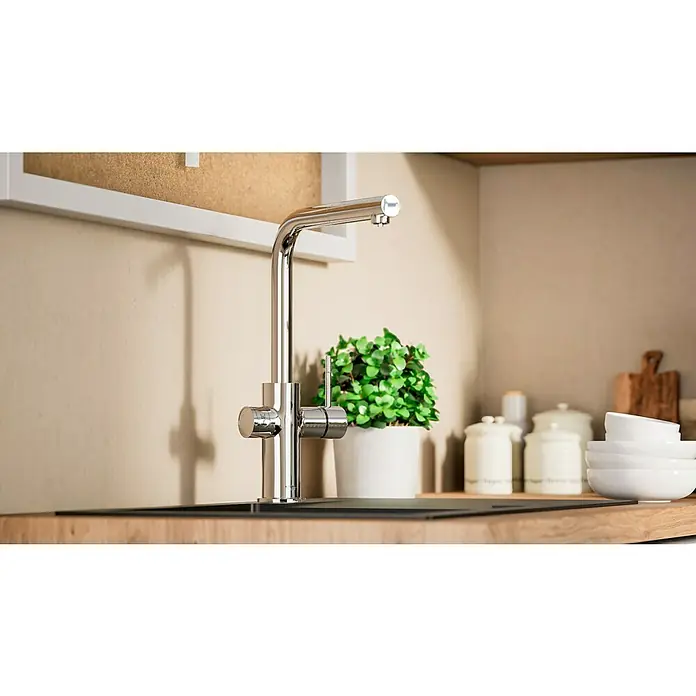 Grohe Spültischarmatur Blue Home - Höhe: 36,8 cm, L-Auslauf, Chrom, Glänzend, Schwenkbar - Küchenarmatur aus Chrom vor Pflanze in weißem Topf und Keramikdosen. Sie ist modern und glänzend und passt gut in moderne Küchen.
