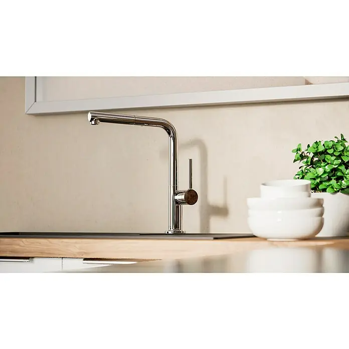 Hansgrohe Grifo de cocina Talis M54 270 - Cromo, Brillante - Primer plano de un moderno grifo de cocina de acero inoxidable con una pila de cuencos blancos y una planta en maceta al fondo.
