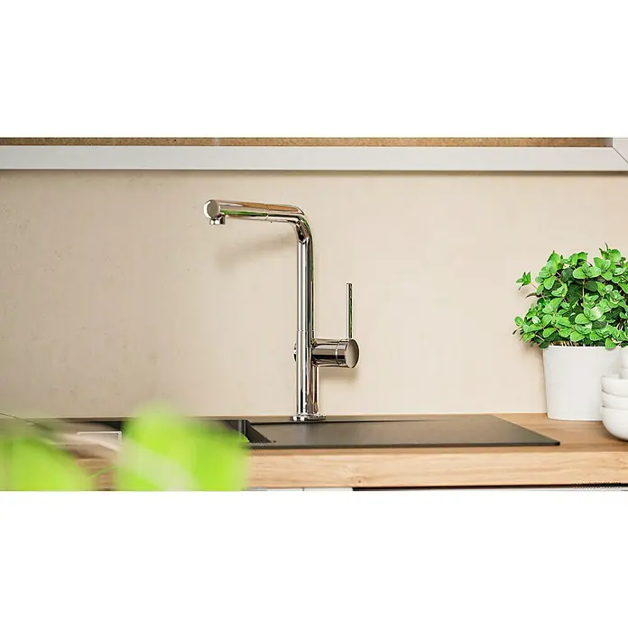 Hansgrohe Grifo de cocina Talis M54 270 - Cromo, Brillante - Primer plano de un moderno grifo de cocina cromado en una encimera, con menta fresca al fondo. Práctico y elegante.
