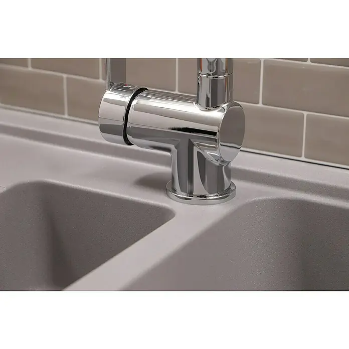 Respekta Einbauspüle Austin - 100 x 50 cm, Grau, Anzahl Becken: 1,5 Stk. - Nahaufnahme eines glänzenden, modernen Chrom-Wasserhahns auf einer grauen Spüle mit einem Hintergrund aus braunen Fliesen.