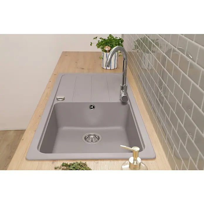 Respekta Einbauspüle Austin - 100 x 50 cm, Grau, Anzahl Becken: 1 Stk. - Graues Spülbecken mit Abtropffläche, Armatur und Spülmittelspender auf einer hellen Arbeitsplatte vor grau gefliester Wand.