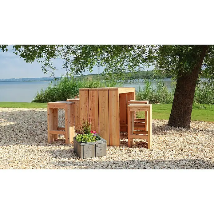 Joda Bartisch-Set Plön - 3 -tlg., Lärche, Natur - Foto eines rustikalen, hölzernen Bistrotisches mit Hockern im Freien, ideal für entspannte Momente mit Seeblick. Der Tisch wird durch einen Blumenkasten ergänzt.