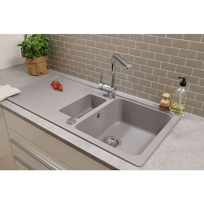 Respekta Einbauspüle Austin - 100 x 50 cm, Grau, Anzahl Becken: 1,5 Stk. - Bild einer modernen grauen Küchenspüle mit Armatur, Abtropffläche und einigen Küchenutensilien auf der Arbeitsfläche.