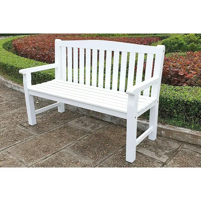 Joda Gartenbank Melbourne 2er-Sitzer - B x T x H: 132 x 58 x 90 cm, Eukalyptus, Weiß - Eine strahlend weiße Gartenbank aus Holz steht auf einem gepflasterten Untergrund, umgeben von üppigem Grün. Die Bank lädt zum Verweilen ein.