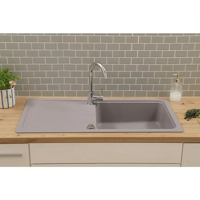 Respekta Einbauspüle Austin - 100 x 50 cm, Grau, Anzahl Becken: 1 Stk. - Eine moderne Küchenspüle mit Abtropffläche, umgeben von einer hölzernen Arbeitsplatte, vor einer grauen Backsteinmauer.