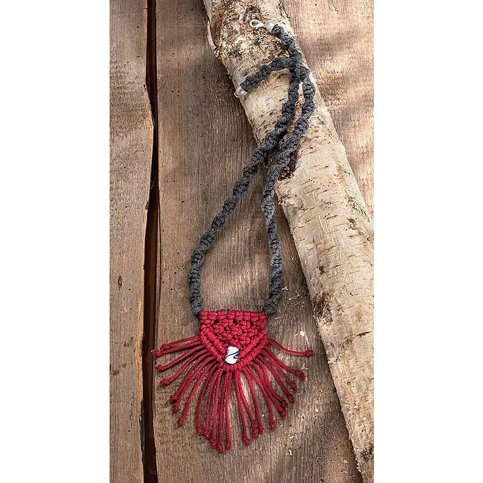 Glorex Wolle Makramee-Cotton - Bordeaux, Durchmesser: 2 mm, 250 g - Nahaufnahme einer roten Makramee-Halskette mit einem grauen Halsband, die auf einem rustikalen Holzhintergrund liegt.