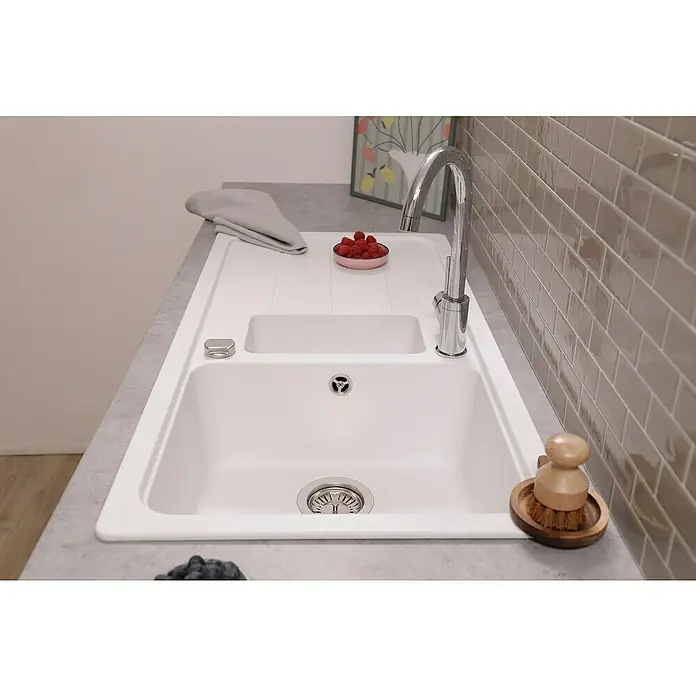 Respekta Einbauspüle Austin - 100 x 50 cm, Weiß, Anzahl Becken: 1,5 Stk. - Eine moderne, weiße Küchenspüle mit Abtropffläche, umgeben von einer Arbeitsplatte in Betonoptik und einer grauen Fliesenspiegel.