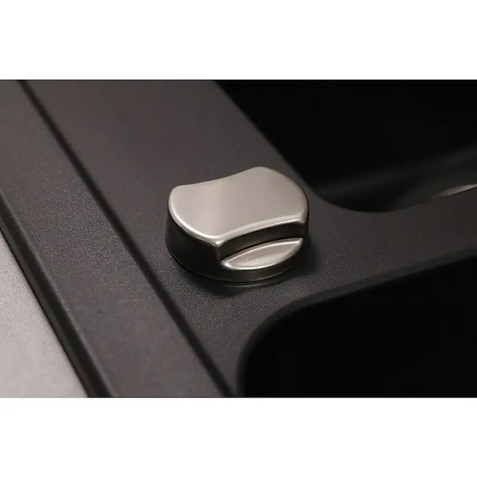 Respekta Einbauspüle Austin - 100 x 50 cm, Schwarz, Anzahl Becken: 1,5 Stk. - Detailaufnahme eines silbernen Knopfes auf einer schwarzen Oberfläche. Der Knopf hat eine abgerundete Form und scheint aus Metall zu sein.