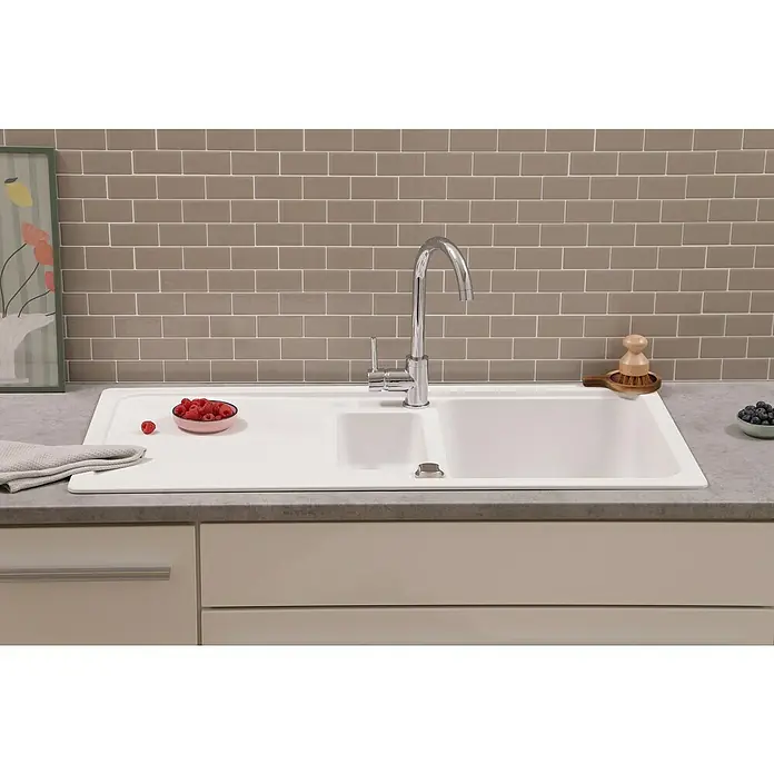 Respekta Einbauspüle Austin - 100 x 50 cm, Weiß, Anzahl Becken: 1,5 Stk. - Nahaufnahme einer modernen Spüle mit Armatur, Früchten und Spülbürste auf einer Küchentheke.
