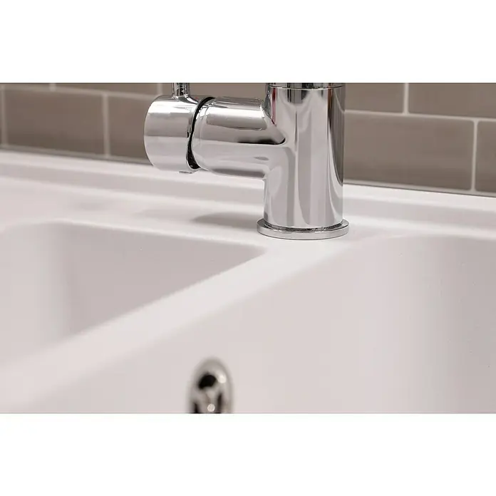 Respekta Einbauspüle Austin - 100 x 50 cm, Weiß, Anzahl Becken: 1,5 Stk. - Nahaufnahme eines glänzenden Chrom-Wasserhahns auf einem weißen Spülbecken mit grauem Fliesenspiegel, der ein sauberes und modernes Design zeigt.