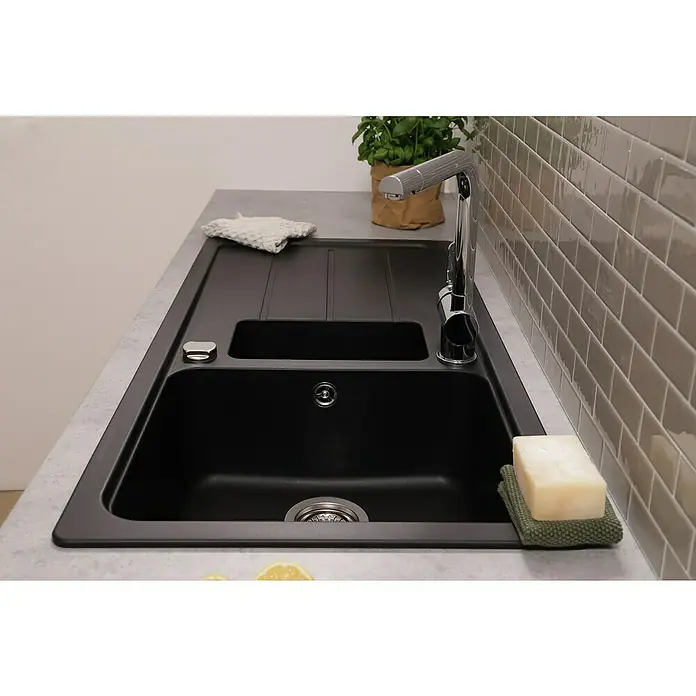 Respekta Einbauspüle Austin - 100 x 50 cm, Schwarz, Anzahl Becken: 1,5 Stk. - Nahaufnahme einer modernen schwarzen Spüle mit Abtropffläche, Armatur und Seife, die ein elegantes Küchendesign zeigt.