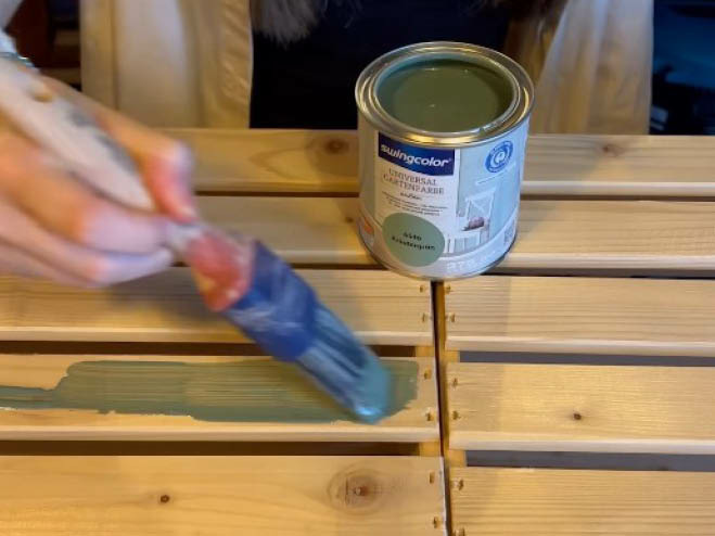 Die Holzkisten werden mit einer grünen Kreidefarbe bestrichen
