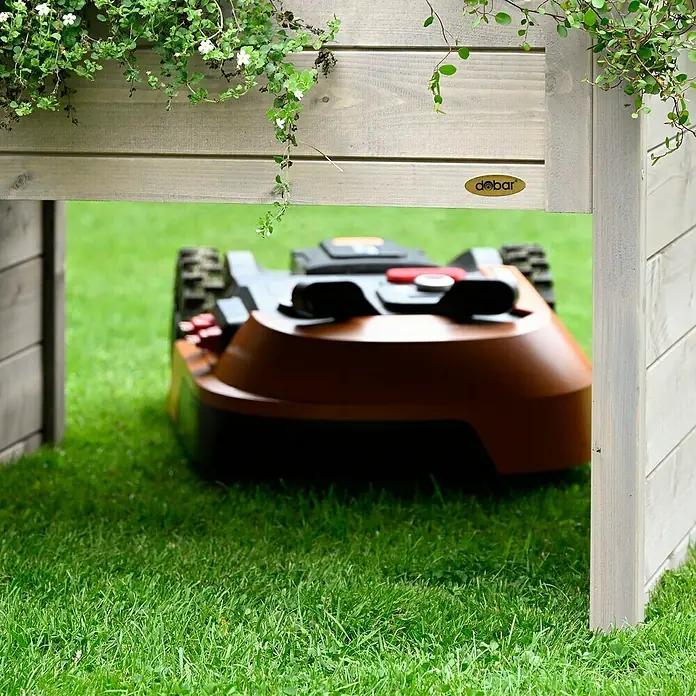 Dobar Mähroboter-Garage - L x B x H: 73 x 79 x 56 cm, Grau - Ein automatischer Rasenmäher parkt unter einem Holzunterstand mit Pflanzen auf dem Dach.