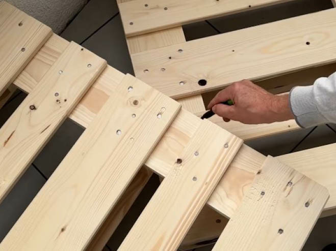 Zwei Paletten sind aufeinandergelegt und mit einem Stift wird die Kante eingezeichnet, die weggeschnitten wird
