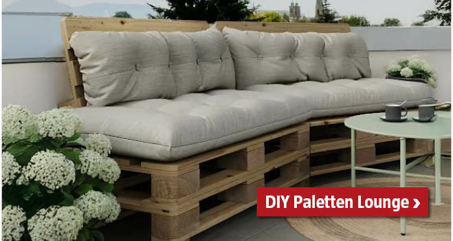 Selbstgemachte Lounge aus Paletten am Balkon mit grauen Polstern