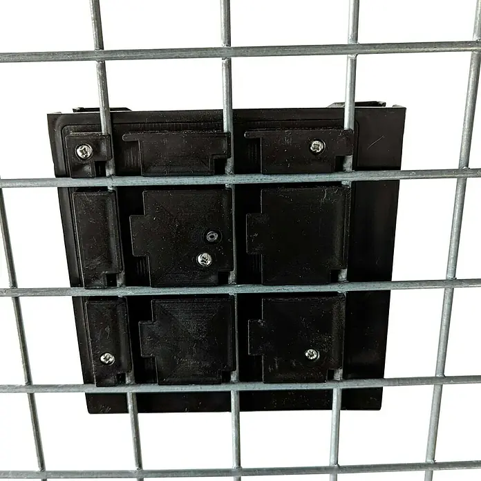 Gabiona Pflanztopf - Kunststoff, Anthrazit - Draufsicht auf eine schwarze Kunststoff-Kabelführung mit Schrauben an einem Metallgitter, die Kabel ordentlich und sicher verlegt.