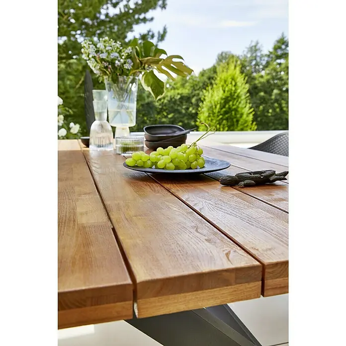 Gartenmöbel-Set Annika - 7 -tlg., Holz, Anthrazit/Schwarz/Flint Grey - Nahaufnahme eines Holztisches im Freien mit Trauben, Schalen und Blumen, der die natürliche Schönheit und Eleganz des Tisches hervorhebt.