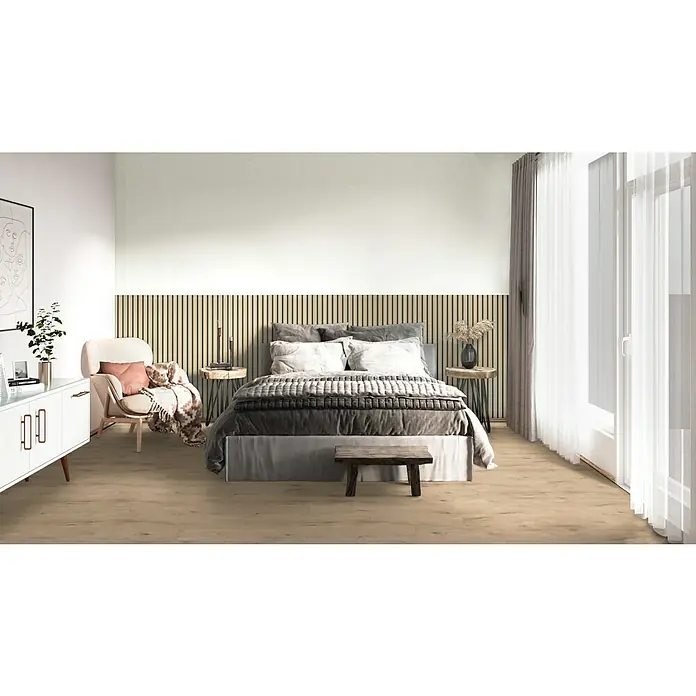 Sonido Akustikpaneel Elements - New Oak Light, L x B x S: 1.200 x 560 x 18 mm - Schlafzimmer mit Doppelbett, Nachttischen, weißer Kommode und beigem Sessel. Der Boden ist aus hellem Holz und die Wände sind weiß und mit Holzpaneelen versehen.