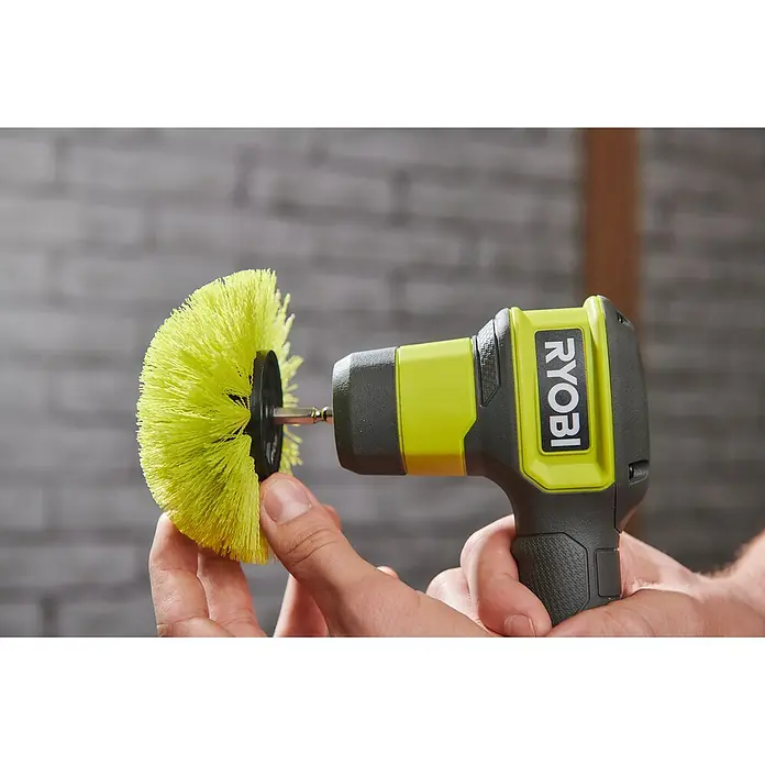 Ryobi Ersatzbürstenkopf RACLRM110 - Standard, Passend für: Ryobi Akku-Reinigungsbürste RSCR4 - Nahaufnahme eines Ryobi-Bohrmaschinenaufsatzes mit gelber Bürste, der von einer Hand gehalten wird.