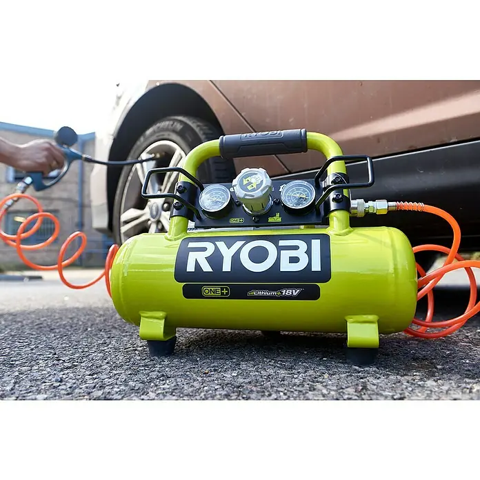 Ryobi ONE+ Akku-Kompressor PRO - 18 V, 3,8 l, 8,3 bar, Ohne Akku - Nahaufnahme eines tragbaren Ryobi ONE+ 18V Akku-Luftkompressors auf Asphalt, der für Reifendruck verwendet wird.