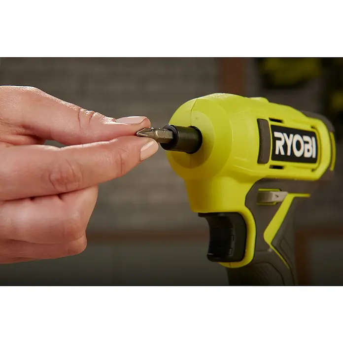 Ryobi ONE+ Akkuschrauber RSD18-0 - 18 V, Ohne Akku, 18 Nm - Nahaufnahme eines gelben Ryobi-Akkuschraubers, eine Hand hält einen Schraubendreherbit bereit, um ihn einzusetzen.