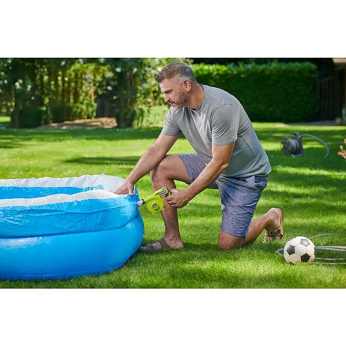 Ryobi 4V USB Akku-Gebläse RVI4-0 - 4 V, Ohne Akku, Luftmenge: 200 l/min - Mann bläst einen Pool mit einer Ryobi-Luftpumpe auf. Der Pool ist blau und weiß und befindet sich auf einer grünen Wiese.